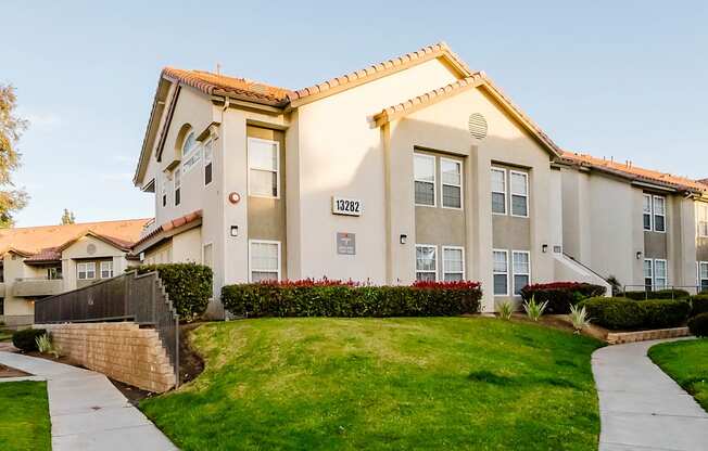 A residential house with a well-maintained lawn and a clear sky.