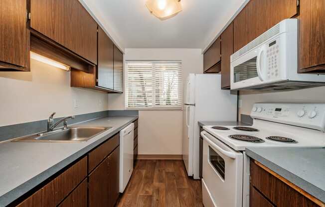 a kitchen with white appliances and wooden cabinets