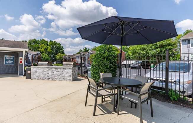 a patio with a table with chairs and an umbrella