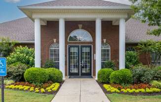 the front entrance of a brick building with columns and a porch