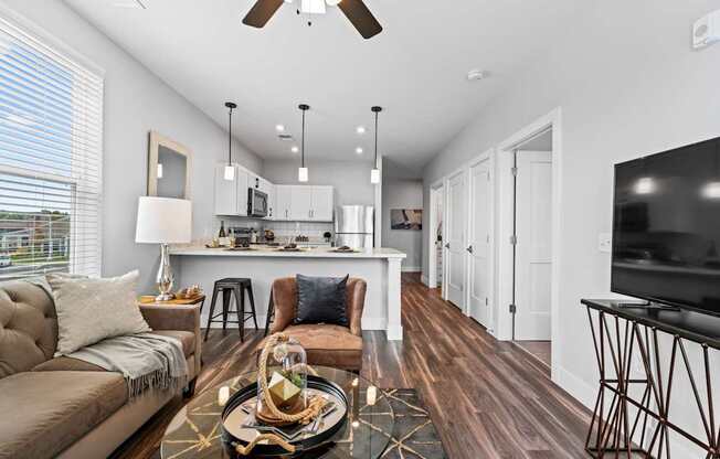 A modern living room with a brown sofa and a wooden floor.