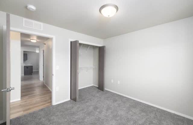 A room with a grey carpet and white walls.