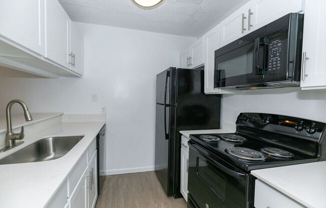 Kitchen with black appliances in white cabinets at Elme Marietta Apartments, Marietta, GA