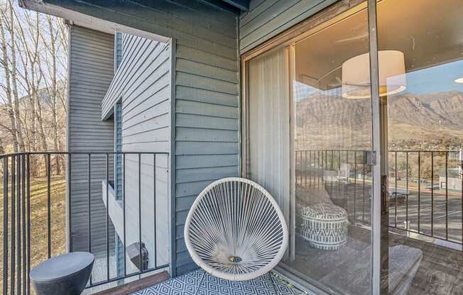 A white fan is on a patio with a view of the mountains.