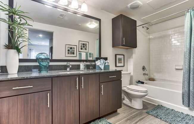 a bathroom with wooden cabinets and a toilet and a sink at Legacy Flats, Texas, 78254