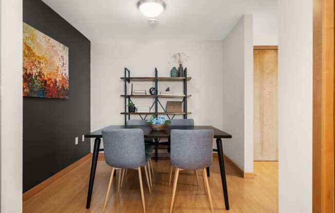 a dining room with a table and chairs and a black wall