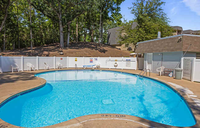 our resort style swimming pool is in front of our house with trees