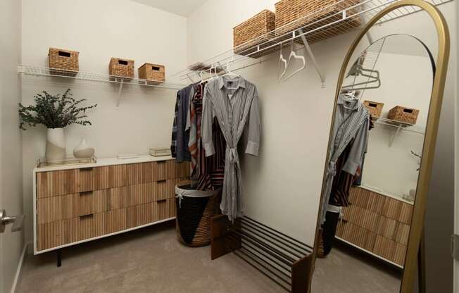 A room with a white wall and a wooden cabinet with drawers.
