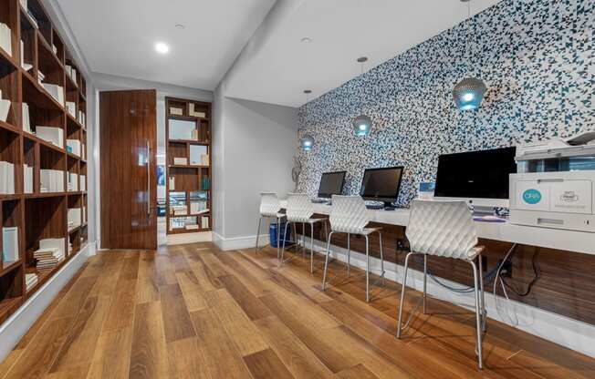 a home office with a blue and white wallpaper and a desk with two computer monitors