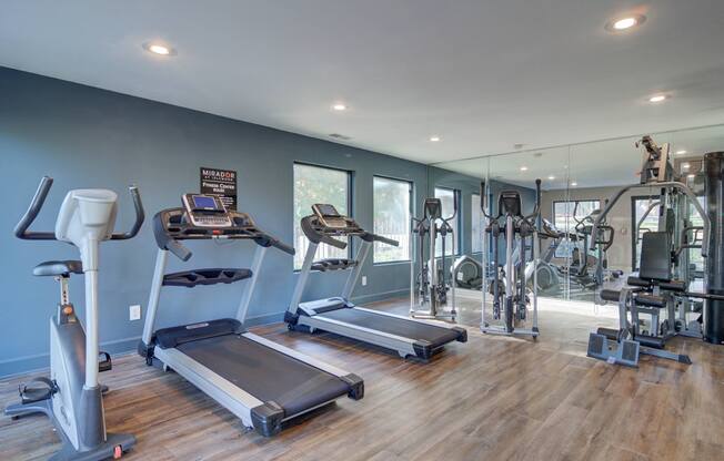 Fully equipped fitness center at Mirador at Idlewood featuring cardio machines, free weights, and strength training equipment.