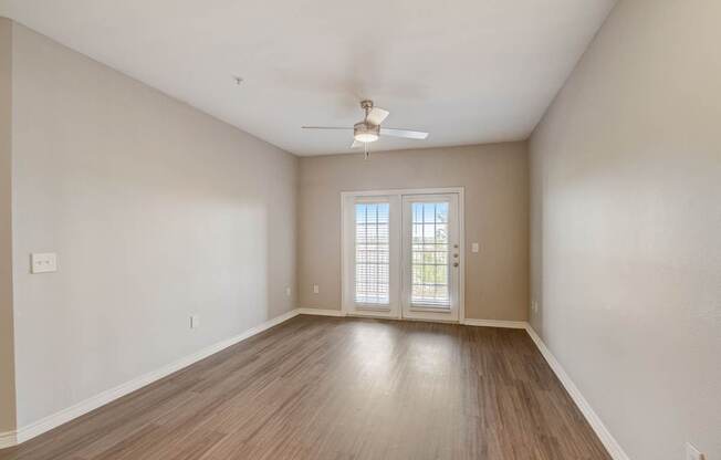 A room with a sliding glass door and a ceiling fan.