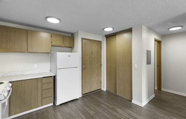 Very Spacious kitchen with a white refrigerator and freezer and wooden cabinetry at Willows Court Apartment Homes, Seattle, 98125