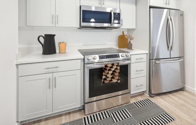 a kitchen with stainless steel appliances and white cabinets