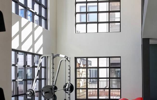 Weight rack with several benches in fitness area with extra tall ceilings at Novel Cary