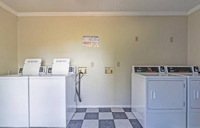 Element at 4411 Macon Apartments A laundry room with washers and dryers and a checkered floor.