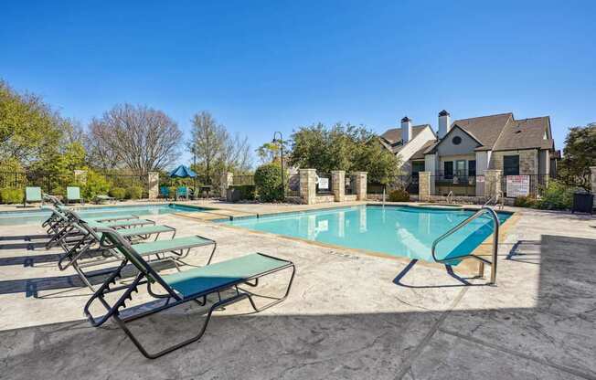 Shot of our pool with lounge chairs at On the Green apartments in Austin, TX