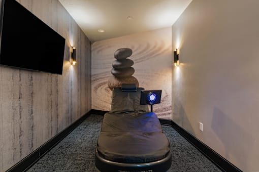 a massage chair in a room with a wall mural and a tv at SevenO2 Main Apartments, Utah, 84101