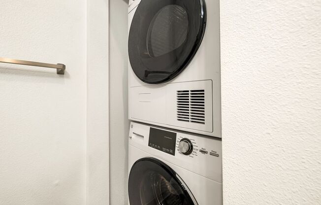 A white washing machine is installed in a wall.