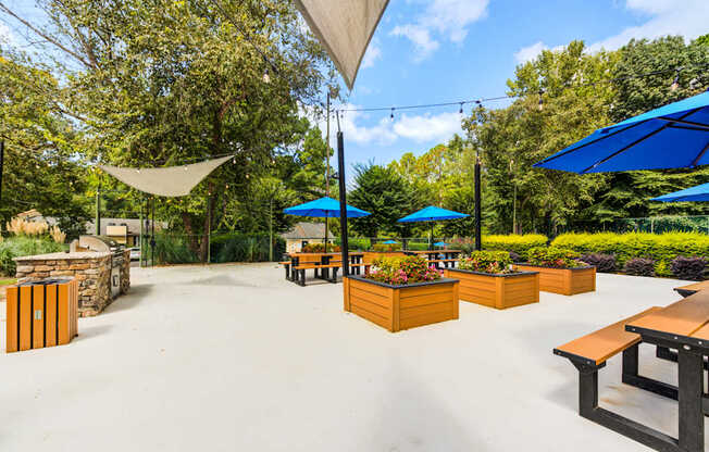 A picnic area with tables and umbrellas at Laurel Oaks in Raleigh, NC.