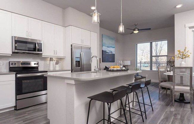 a kitchen with a large island with three bar stools