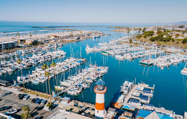 a view of the marina with many boats and a lighthouse