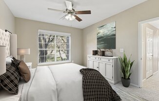 a bedroom with a large bed and a ceiling fan