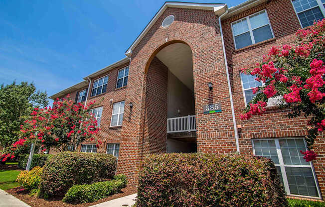 A brick building with a balcony and windows.