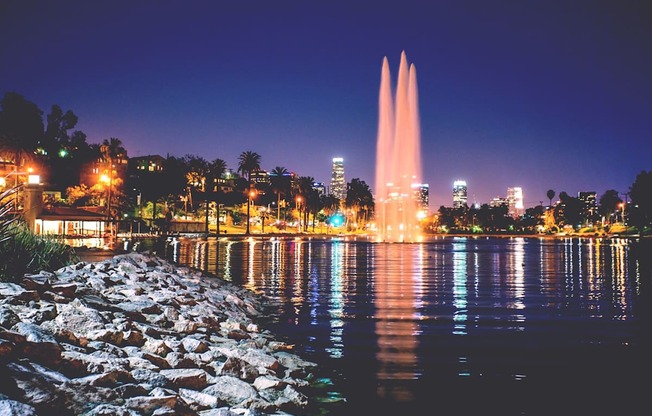 A fountain in the middle of a body of water with a city skyline in the background.at The Dillon, Los Angeles