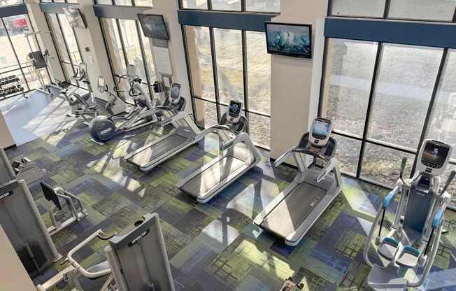 A gym with treadmills, exercise bikes and elliptical machines.