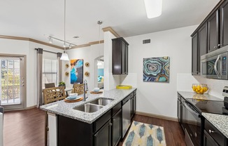 A kitchen with black cabinets and a white counter top.