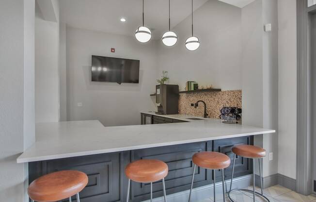 a kitchen with stools and a counter with a sink and a tv at Sladestone Shadow Creek, Pearland, TX, 77584