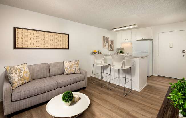 A living room with a grey couch and a white coffee table.