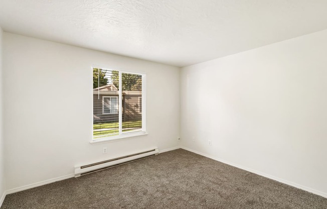 an empty room with carpet and a window  at Park View Apartments, Washington, 98801