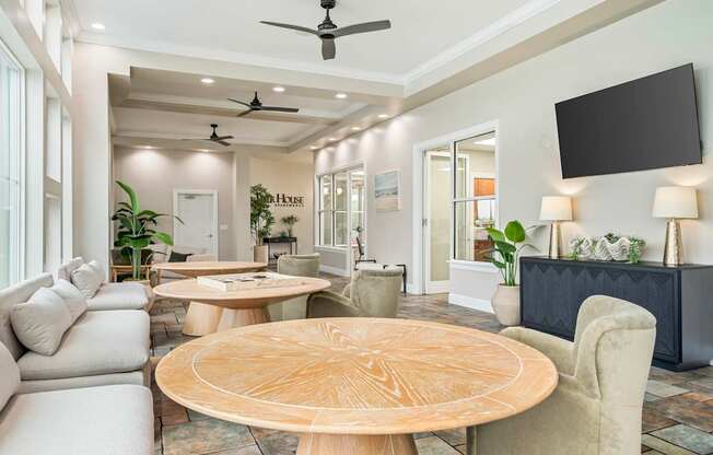 A modern living room with a large wooden table in the center.