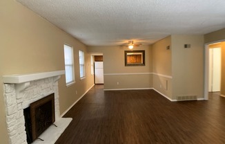 large living room with wood floors and fireplace