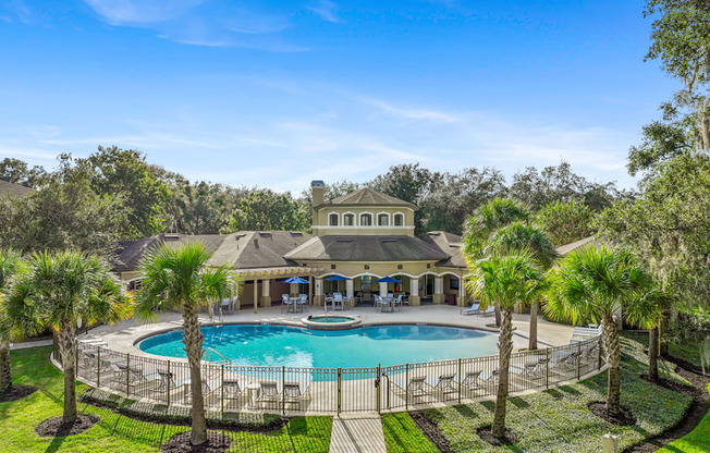 a mansion with a large pool and palm trees