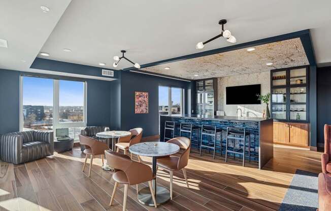 A modern living room with a bar area and a view of the city.