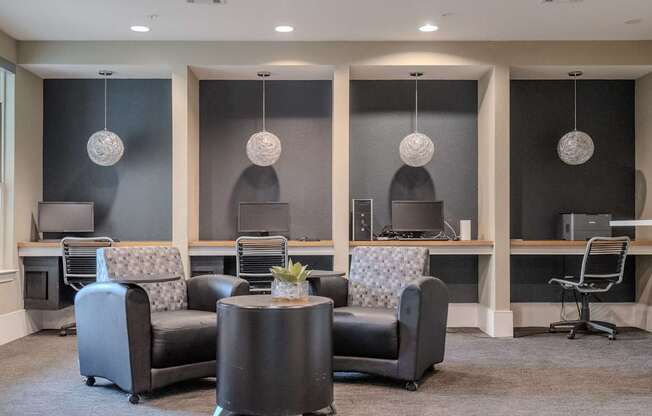 a lounge area with couches and chairs and desks with computers