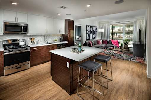 A modern kitchen with a large island and stools.