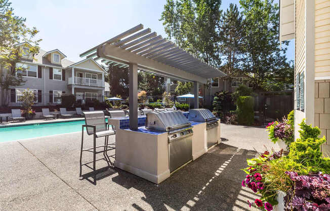 A poolside area with a hot tub and a barbecue grill.
