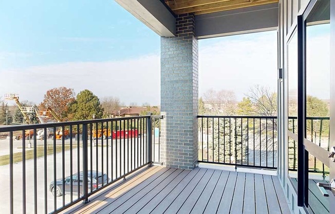 a balcony with a black metal railing and a brick pillar