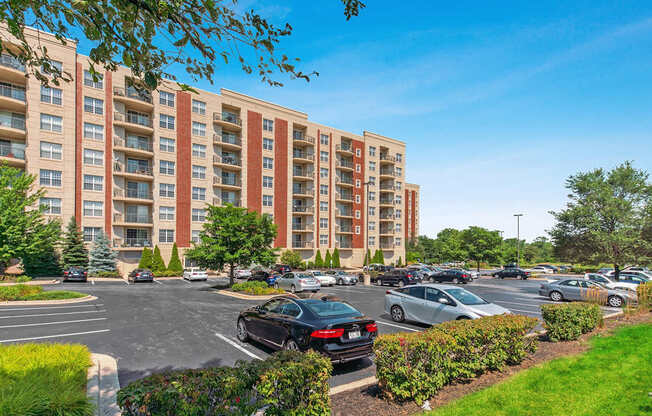 A parking lot in front of a large apartment building.