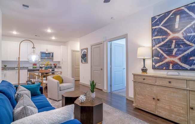 a living room and kitchen with a blue door