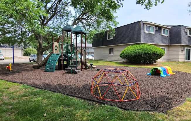 A playground with a swing set, a slide, and a climbing structure.