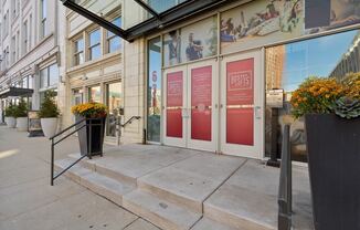 the entrance to a building with three red doors and two steps