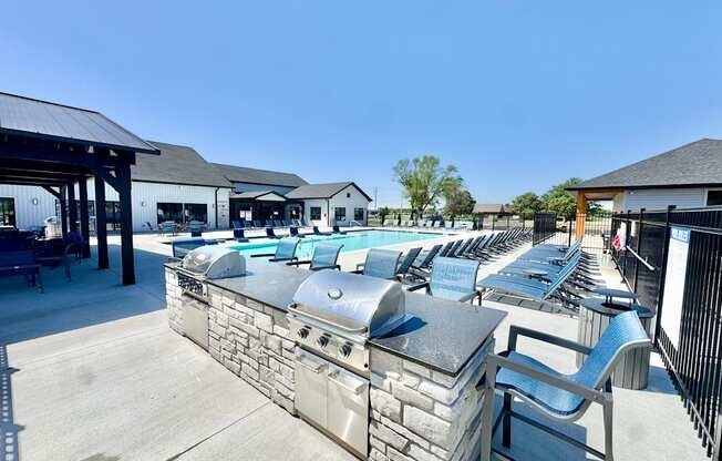 A row of outdoor grills are lined up on a patio.
