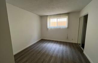 Bedroom with Hardwood Floors and Mirrored Wardrobe Closet