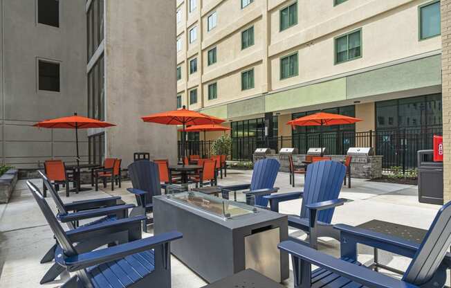 a patio with chairs and umbrellas in front of a building  at The Icon, Richmond, VA, 23230