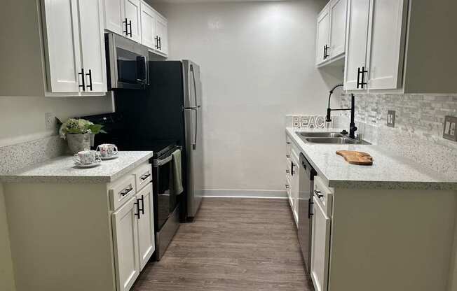 a kitchen with white cabinets and a black stove and refrigerator