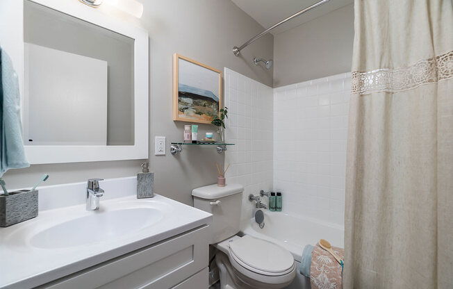 a bathroom with a sink toilet and a mirror at The Heights Apartments, Cincinnati, 45220